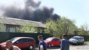 Gyventojai stebi dūmus kilstant iš gaisro po šaudymo.