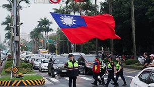 Vyras su Taivanio vėliava lydimas policijos Taipejyje. / Ann Wang / REUTERS/