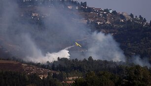 Gelbėjimo komandos gesina namo liepsnas Izraelyje po raketos i&scaron;puolio. / Jim Urquhart / REUTERS