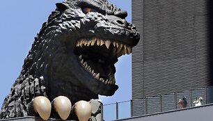 Žmonės fotografuoja Godzilos galvą prie &bdquo;Toho&ldquo; pastato Tokijuje. / Koji Sasahara / AP