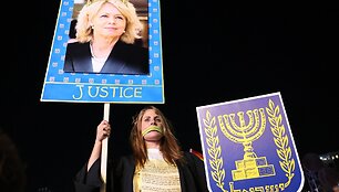 Demonstrantė laiko plakatą su Izraelio generalinės prokurorės atvaizdu / JACK GUEZ / AFP