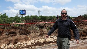 Izraelio policininkai tiria smūgio kraterį po husių raketos smūgio Ben Guriono oro uostui / Nir Elias / REUTERS