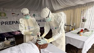 Gydytojai mobilioje laboratorijoje, kurios naudojamos Ebola viruso atvejams nustatyti