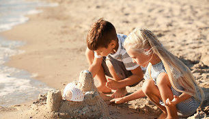 Vaikai žaidžia su smėliu