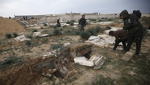 Palestinečiai apžiūri iškasinėtus kapus Gazos Ruože.