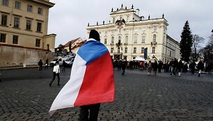 Vyras apsigaubęs Čekijos vėliava eina į Vaclavo Havelo laidotuvių ceremoniją.