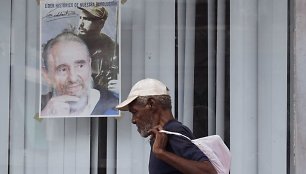 Kubietis eina pro Fidelio Castro, švenčiančio 87-eptintąjį gimtadienį, plakatą.