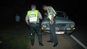 Policininkai prie automobilio, kuris partrenkė moterį su vaiku