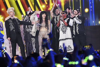 „Eurovizijos“ prizą Loreen įteikė pernykštė nugalėtoja ukrainiečių grupė „Kalush Orchestra“. Kairėje – vienas šiemetinio konkurso vedėjų britų TV žvaigždė Grahamas Nortonas