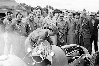 Kartu su tėvu (viduryje) automobilio „Ferrari 166 F2“ bandymą Moncos autodrome stebi ir septyniolikmetis  Dino Ferrari (šeštas iš kairės), 1949-ieji