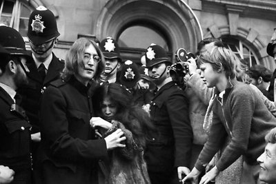 Johnas Lennonas saugo Yoko Ono nuo minios prie Londono teismo, kuriame buvo apkaltinti marihuanos laikymu ir pasipriešinimu policijai. 