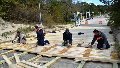 Palangoje perklojamos tilto į jūrą trinkelės.