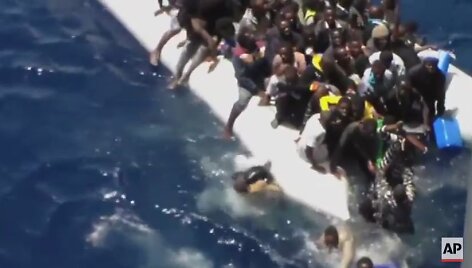 Migrantai Viduržemio jūroje bando i&scaron;sigelbėti i&scaron; skęstančio laivo