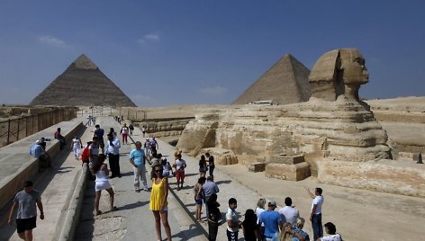 Turistai fotografuojasi prie Sfinkso ir Gizos piramidžių.