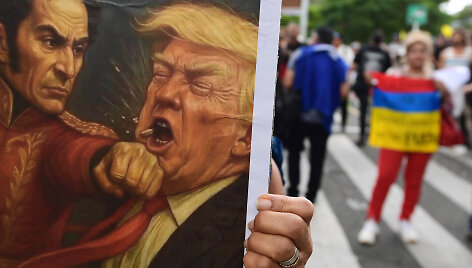 Protestuotojai laiko plakatą, kaip Simonas Bolivaras tariamai smogia Donaldui Trumpui