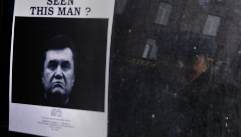 A elderly man looks at a "Wanted" notice for fugitive Ukrainian President Victor Yanukovich, plastered on the window of a car used as barricade near Kiev's Independent Square February 24, 2014. Ukrainian President Viktor Yanukovich, ousted after bloody street protests in which demonstrators were sho