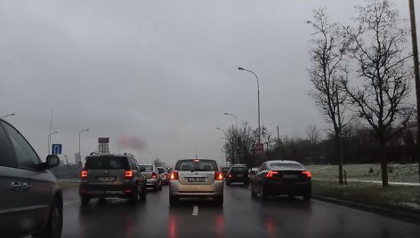 Vaizdo įrašo stop kadras. Trys automobilių eilės dviejų juostų kelyje