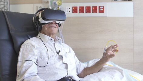 Pacientai naudojasi virtualios realybės akiniais.
