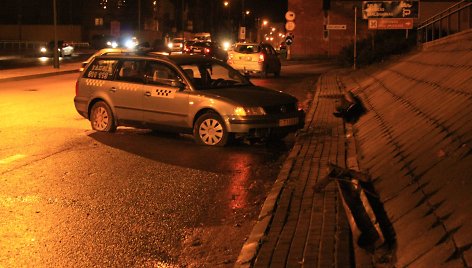 Nuo viaduko nukritus vamzdžiui apgadintas taksi automobilis.