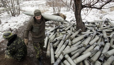 Ukrainos karys eina &scaron;alia krūvos panaudotų artilerijos sviedinių tūtų.