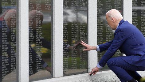 JAV prezidentas Joe Bidenas atiduoda pagarbą karo veteranams ir i&scaron;tiesia ranką, norėdamas paliesti savo dėdės Ambrose'o Finnegano vardą