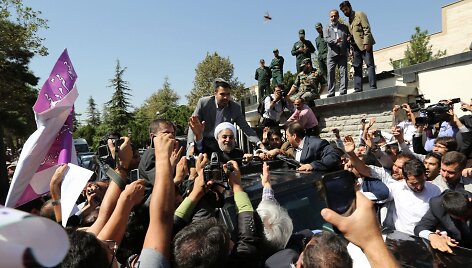 I&scaron; Jungtinių Tautų Generalinės Asamblėjos grįžęs Hassanas Rouhani mojuoja &scaron;alininkams.