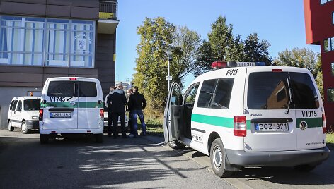 Prie LNK pastato ma&scaron;inoje sėdintis žmogus