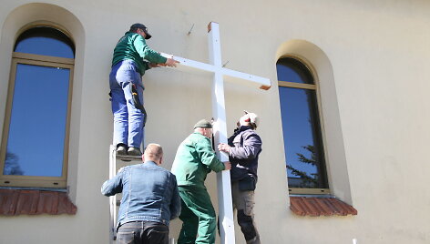 Prie bažnyčios tvirtinamas kryžius