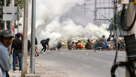 Mianmaro protestuotojai slepiasi už barikadų.