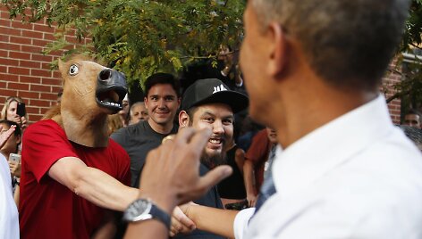 JAV prezidentas Barackas Obama sveikinasi su vyru, dėvinčiu arklio galvos kaukę.