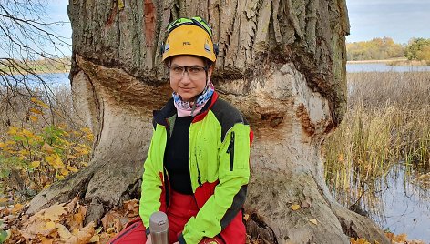 Inga Gaidelytė-Markevičienė prie medžio, kurį bebras graužia trejus metus