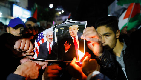 Ramaloje protestuojantys palestiniečiai degina D.Trumpo ir B.Netanyahu nuotrauką.