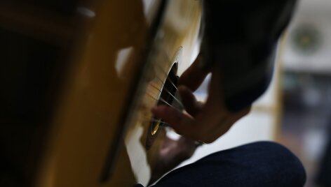 Klientas i&scaron;mėgina gitarą