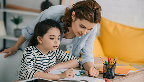 Mama padeda dukrai ruošti namų darbus