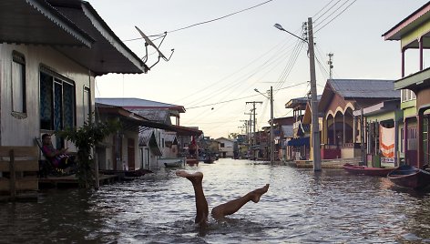 Vaikas žaidžia patvinusioje Amazonės upės vandenyje Brazilijoje