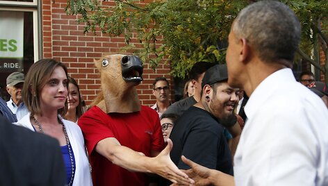 JAV prezidentas Barackas Obama sveikinasi su vyru, dėvinčiu arklio galvos kaukę.