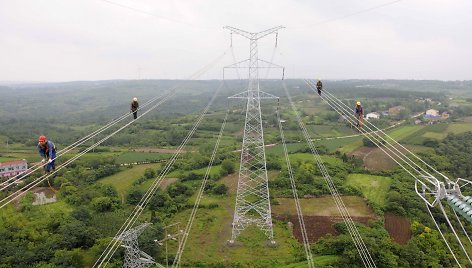 Darbininkai Kinijoje tikrina naujai nutiestą elektros liniją