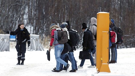 Norvegijos pasienio pareigūnė palydi migrantus
