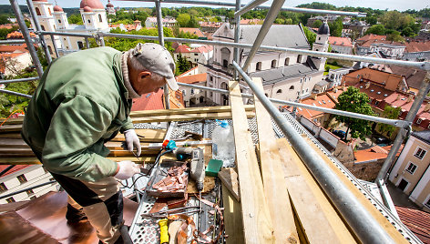 Aukštybėse dirbantys statybininkai tvarko unitų bažnyčios bokštą