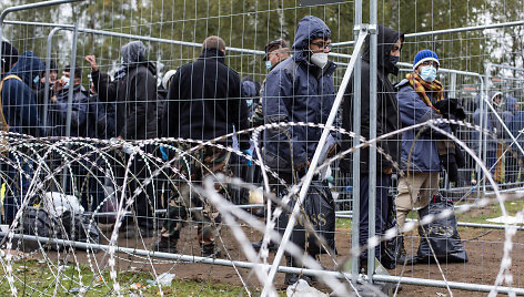 Rūdninkų (Šalčininkų raj.) laikinoje stovykloje migrantai už spygliuotos tvoros vielos eilėje laukia kol bus patikrinti jų dokumentai