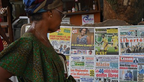 Abidžano (Dramblio Kaulo Krantas) gyventoja skaito laikraščių, skelbiančių apie karių išlaisvinimą, antraštes.
