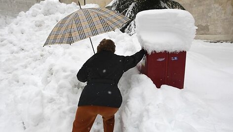 Moteris bando įmesti lai&scaron;ką į pa&scaron;to dežutę.