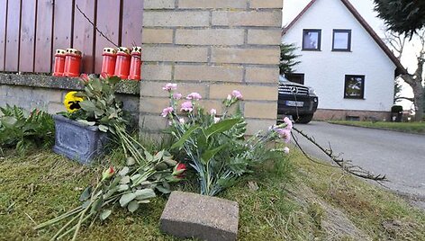 Gėlės ir žvakės padėtos &scaron;alia namo.