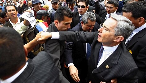 Alvaro Uribe (de&scaron;inėje) yra nepaprastai populiarus savo &scaron;alyje, tačiau nebegalės dar karą būti renkamas prezidentu.