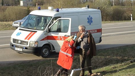 Medikai teikia pagalbą sužeistam autobuso keleiviui