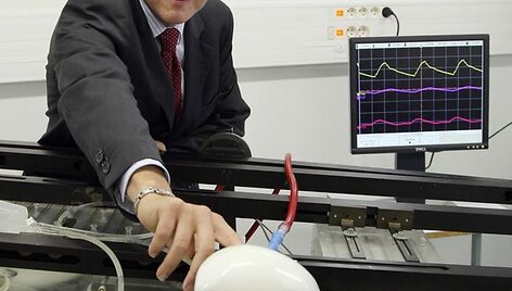 Kompanijos &bdquo;Carmat&ldquo; vadovas Patrickas Coulombieras stovi prie naujojo žmogaus &scaron;irdies prototipo.