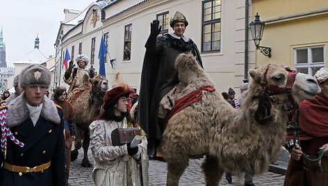 Trijų karalių eisenos prie&scaron;akyje ant kupranugario keliauja karalius Merkelis, jam i&scaron; paskos seka karalius Baltazaras. 