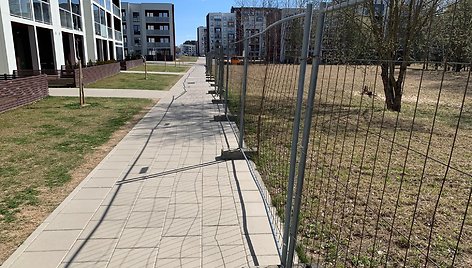 Pilaitės gyventojai piktinasi, kad bendro naudojimo erdvė aptverta statybine tvora ir naudojama kaip privati statybinių medžiagų saugojimo aikštelė