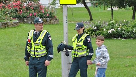 Pareigūnai lydi mokinį