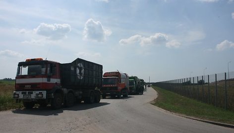 Prie sąvartyno nusidriekė atliekas gabenančių automobilių eilė.